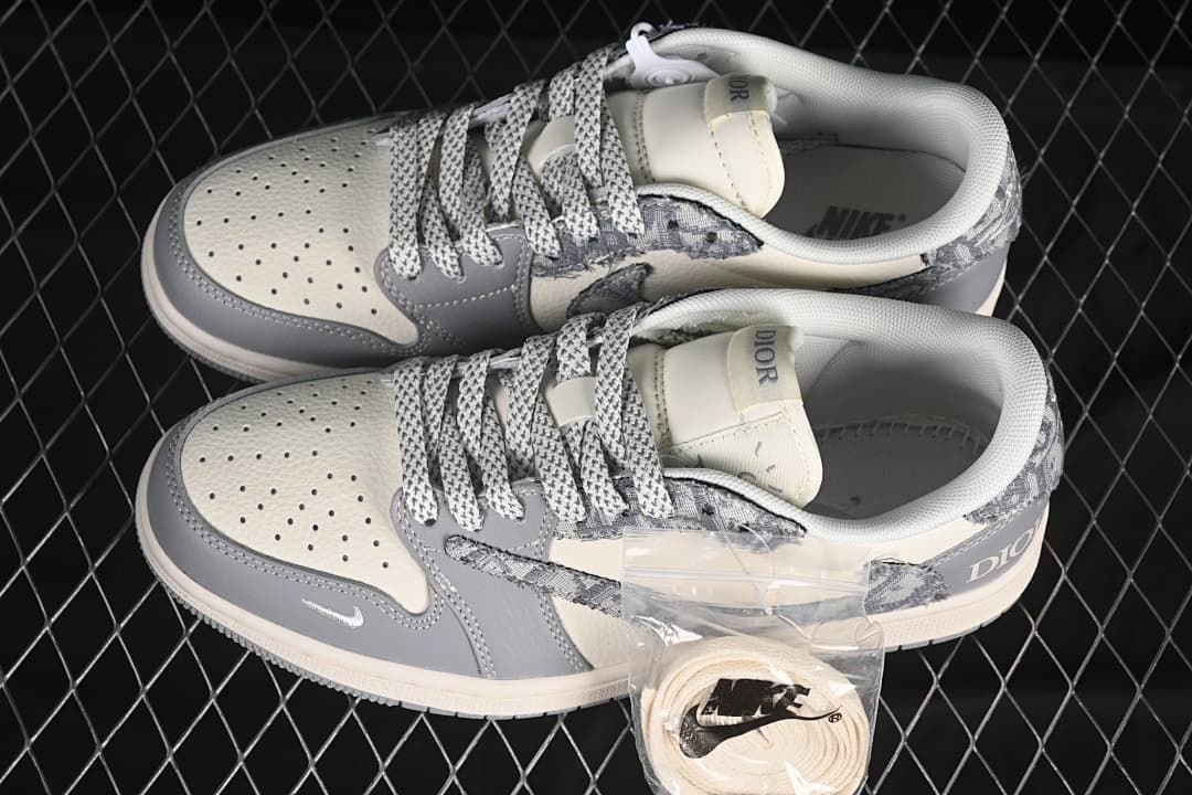 Pair of gray and white low-top sneakers shown from above, with patterned laces and a spare lace set