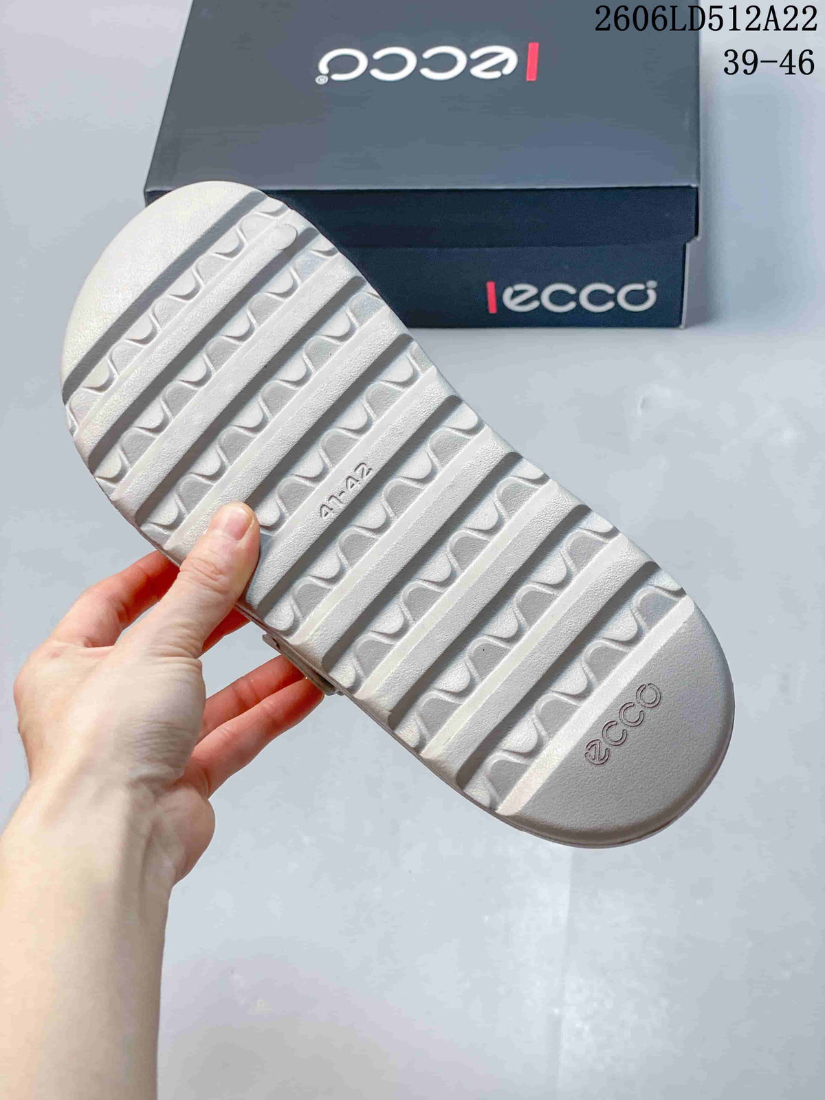 Close-up of the sandal's ridged outsole and ECCO shoe box