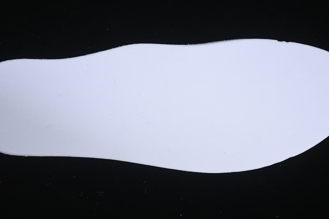 White shoe insole shown against a dark background.