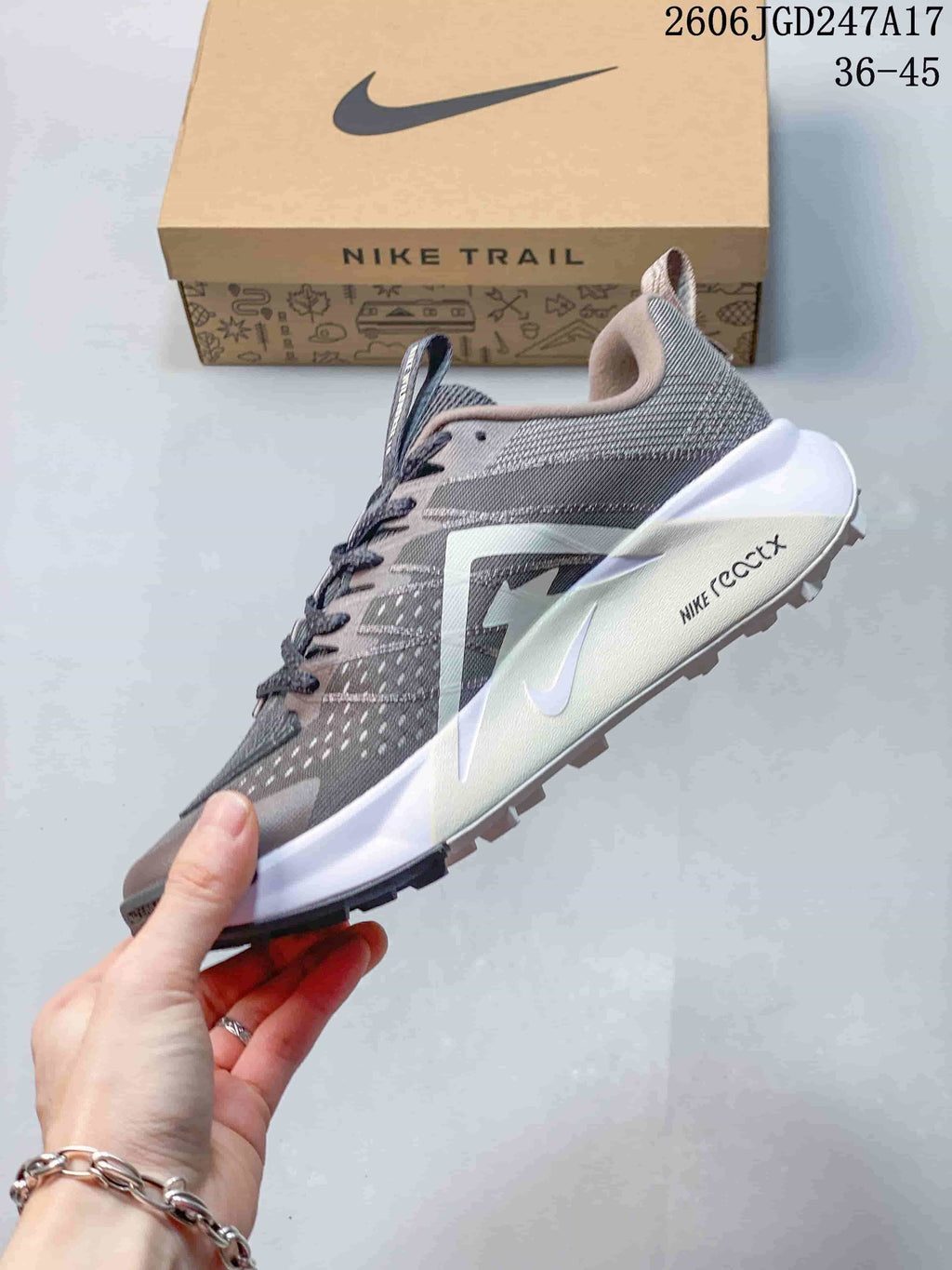 Side view of a Nike Wildhorse 10 trail shoe showing its gray and pink upper and white midsole