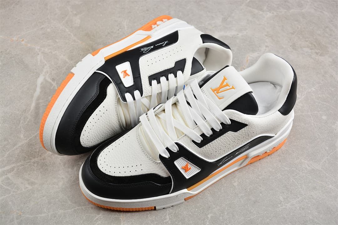 Pair of white, black, and orange LV Trainer sneakers viewed from above