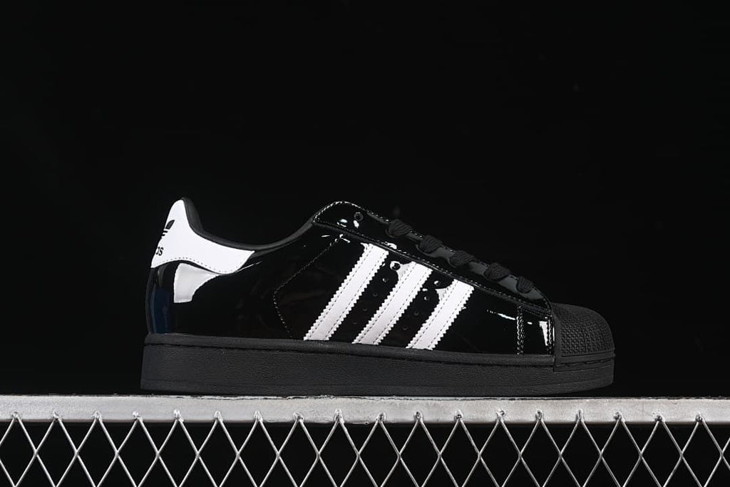 Side view showing the black upper, white stripes, shell toe and outsole