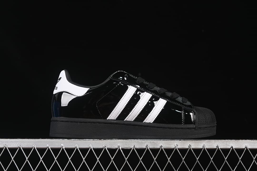 Side view showing the black upper, white stripes, shell toe and outsole