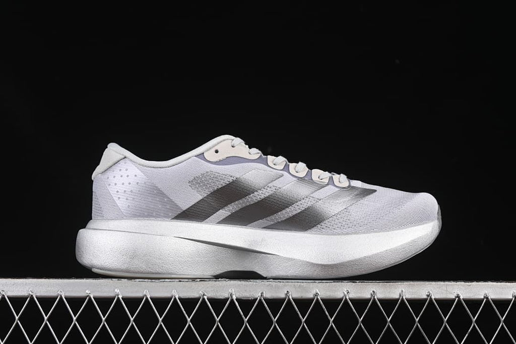 Side profile of the gray running shoe with dark stripes and a thick midsole.