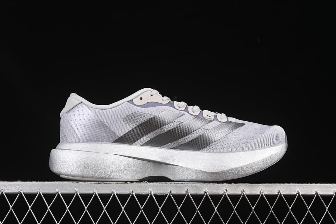 Side profile of the gray running shoe with dark stripes and a thick midsole.