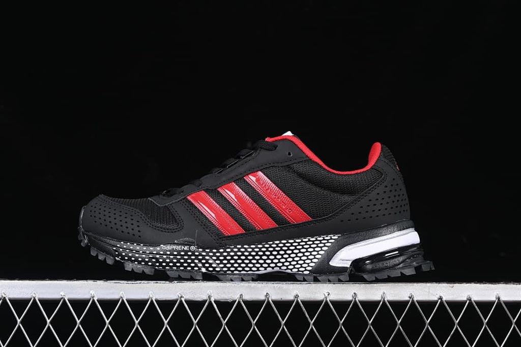 Side view of the black and red sneaker with mesh panels and lugged outsole.