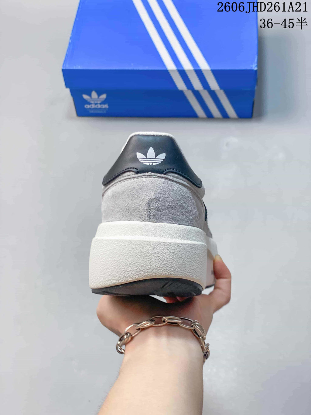 Rear view showing the raised off-white midsole and heel detail of a grey sneaker