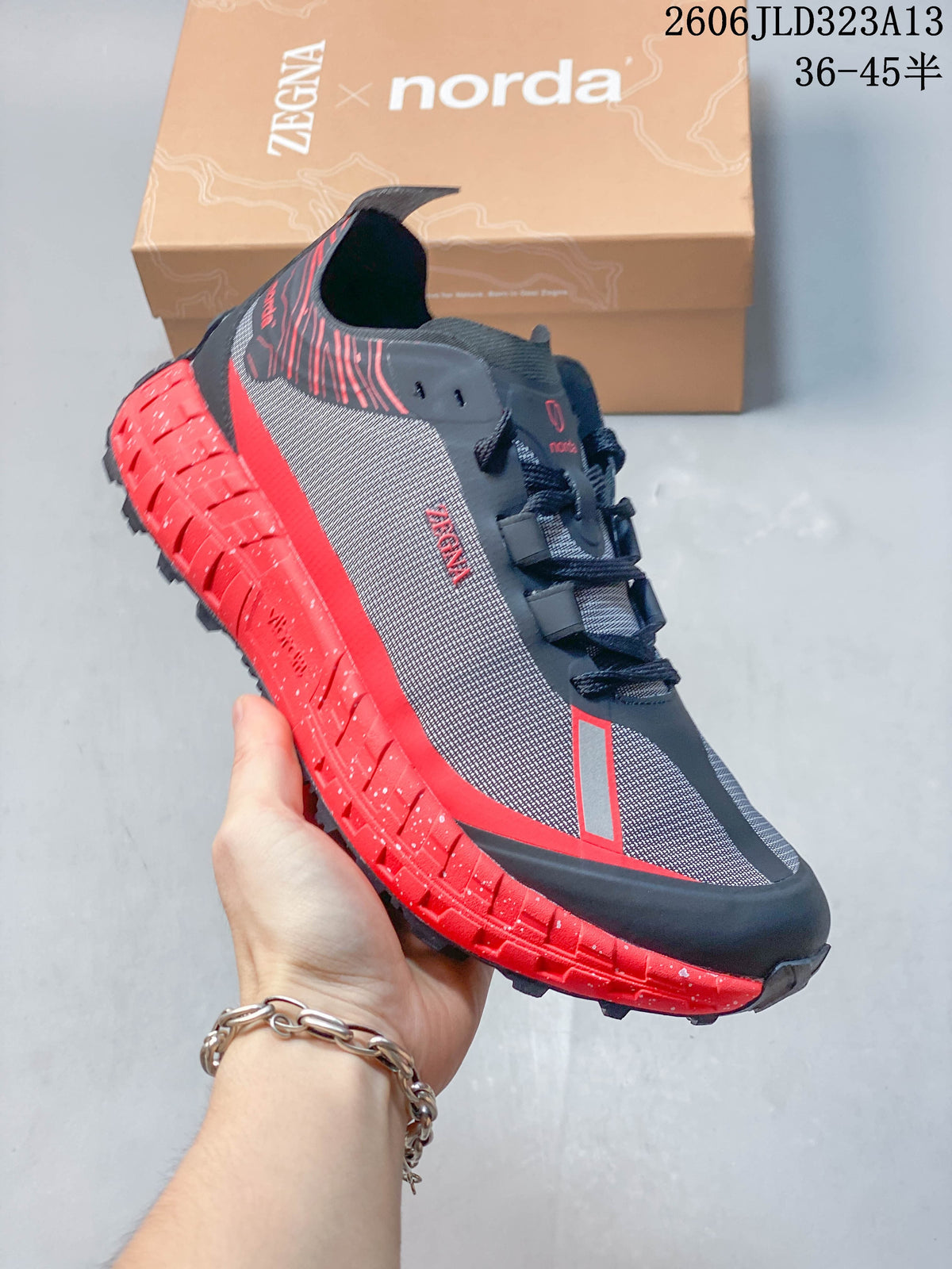 Angled side view of the shoe with its red outsole and charcoal upper