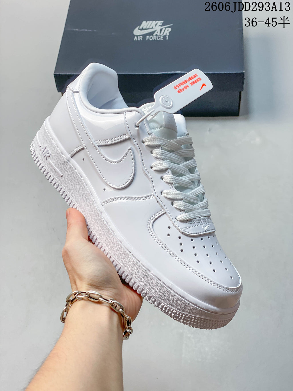 Close-up of a white low-top sneaker with perforated toe, side Swoosh and lace-up front; image overlay shows size range 36–45.5.