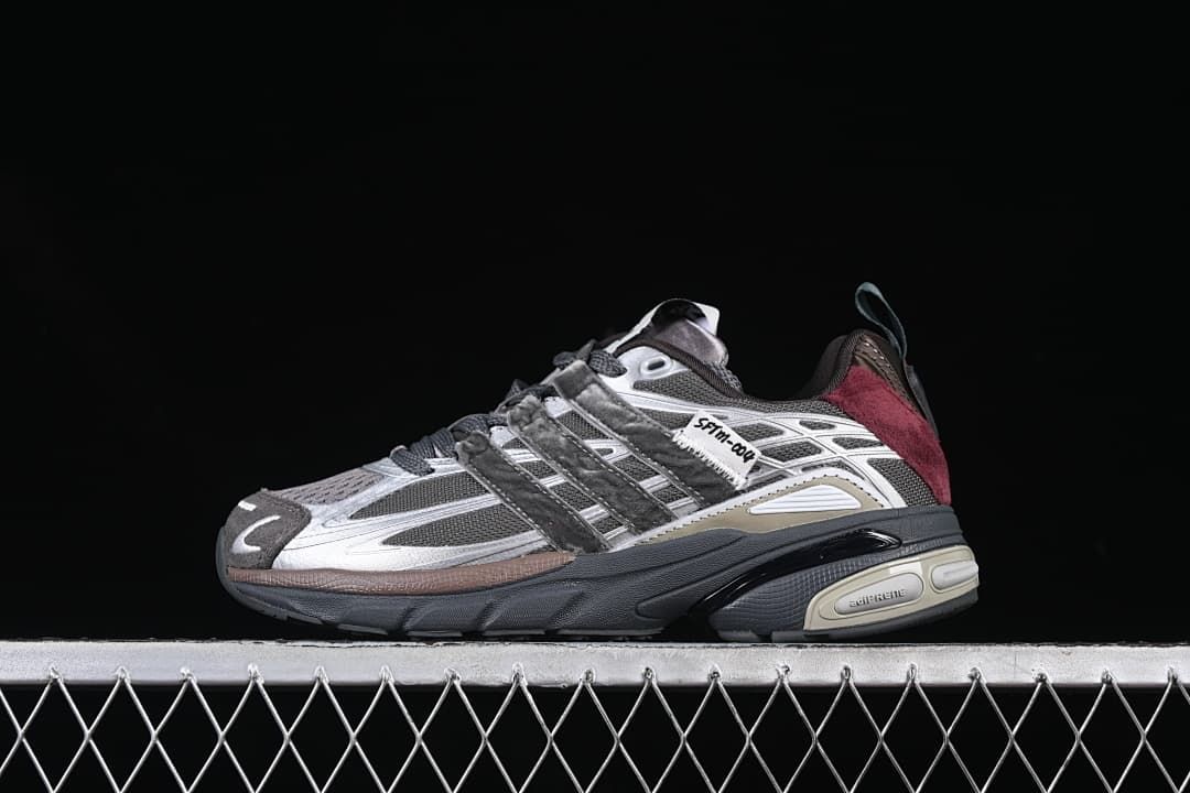 Side view of charcoal and silver-gray adidas Adistar Cushion sneakers with burgundy heel accents.