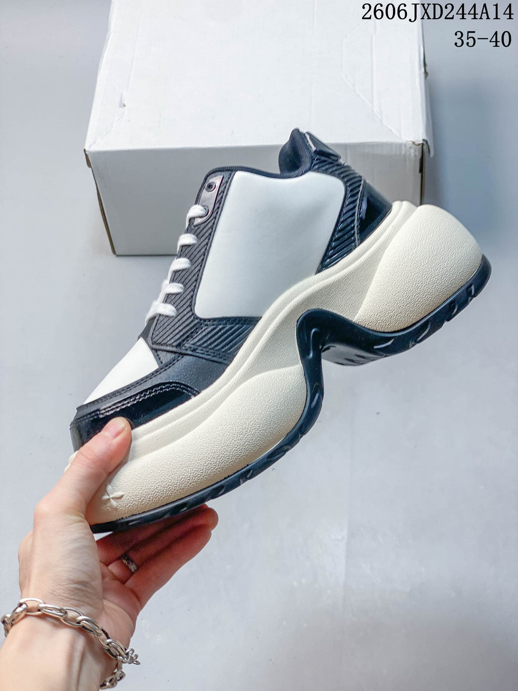 Side view of a white and navy SMFK sneaker with a chunky cream-colored sole