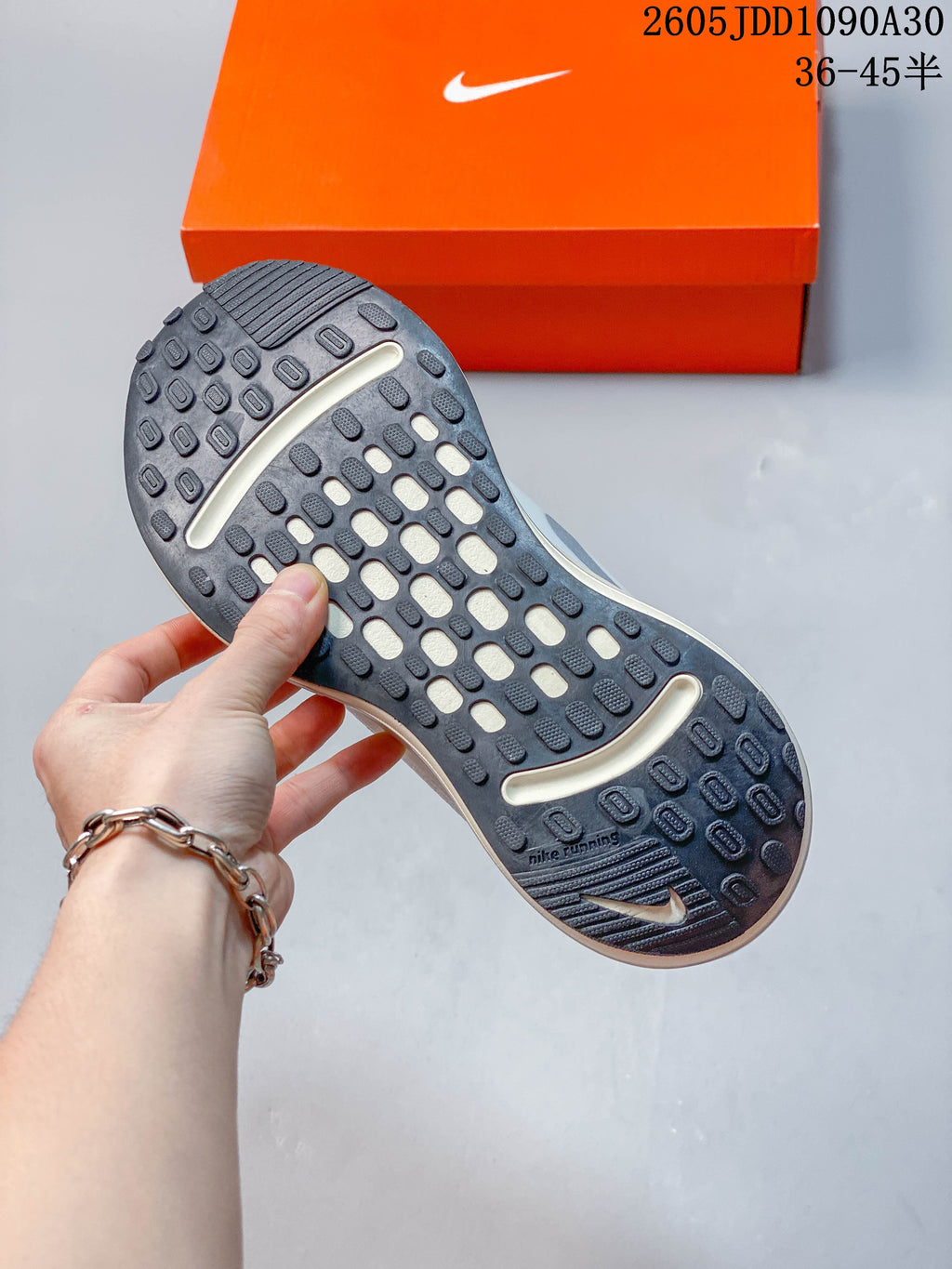 Close-up of the patterned dark outsole of a Nike Journey Run shoe.