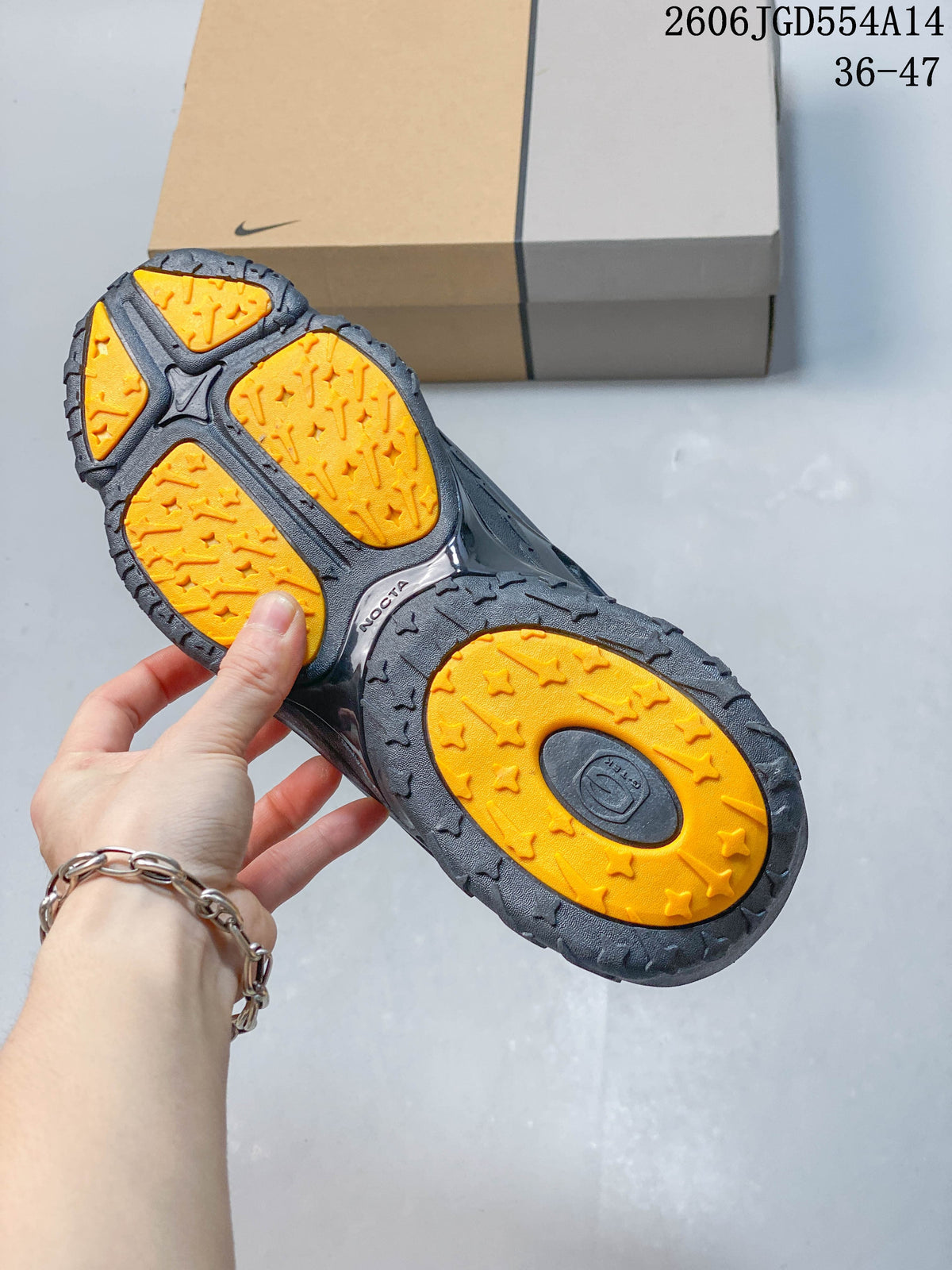 Underside of a Nike NOCTA Hot Step 2 sneaker showing orange outsole sections