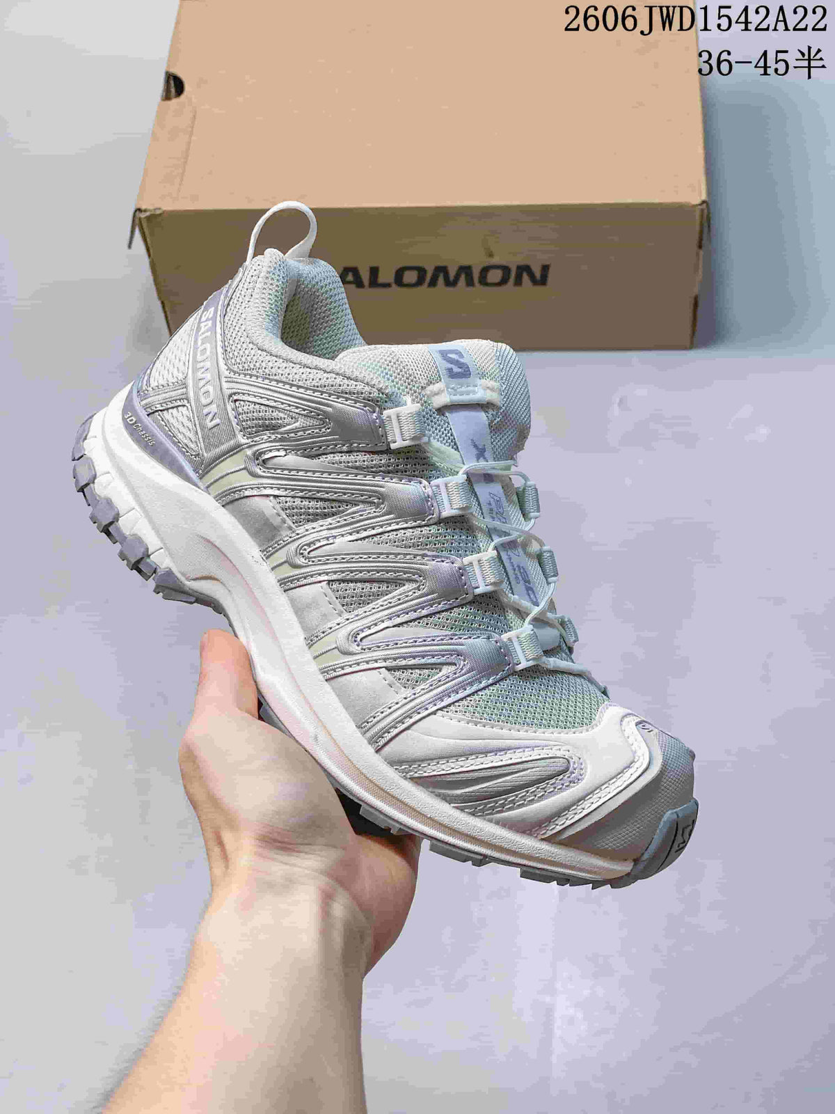 Pale gray Salomon trail-style sneaker with silver-look overlays and a quick-pull lace system.