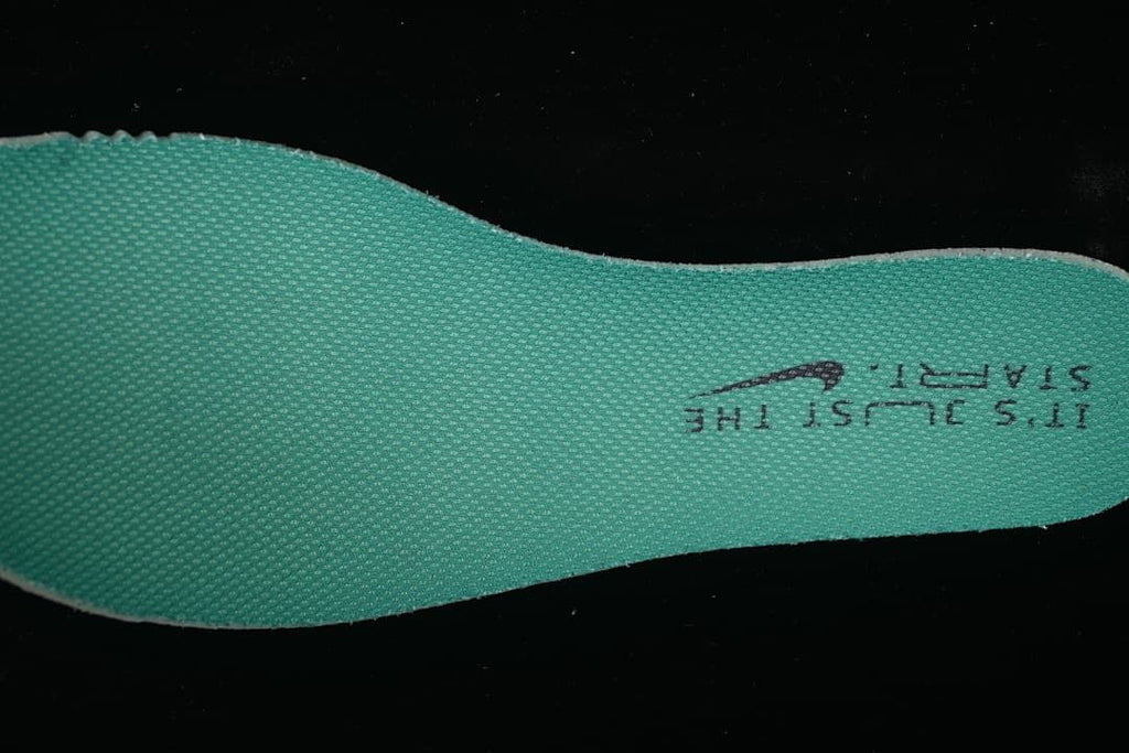 Close-up of a teal shoe insole with printed lettering