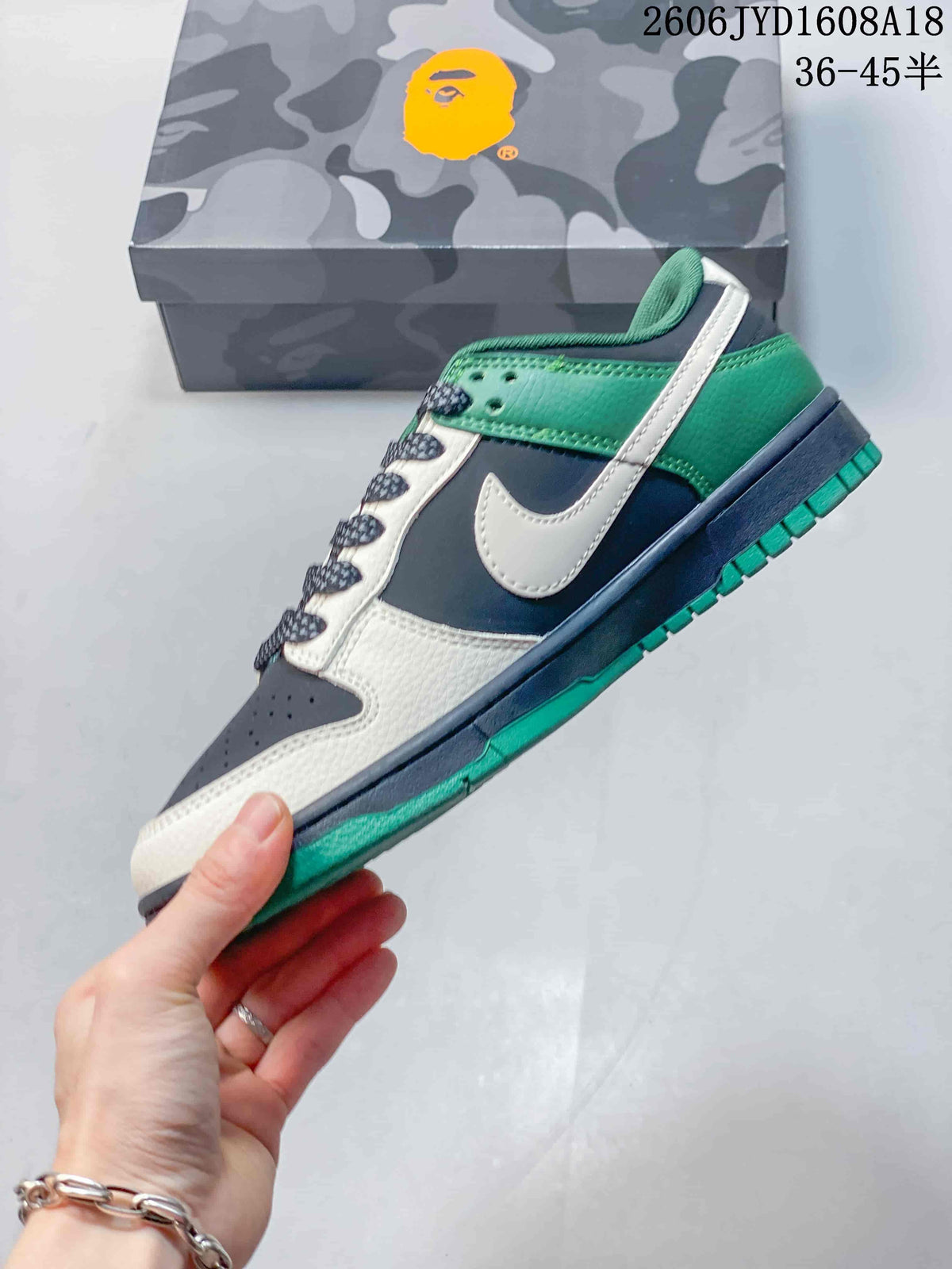 Side view of the low-top sneaker with green, navy, and off-white panels