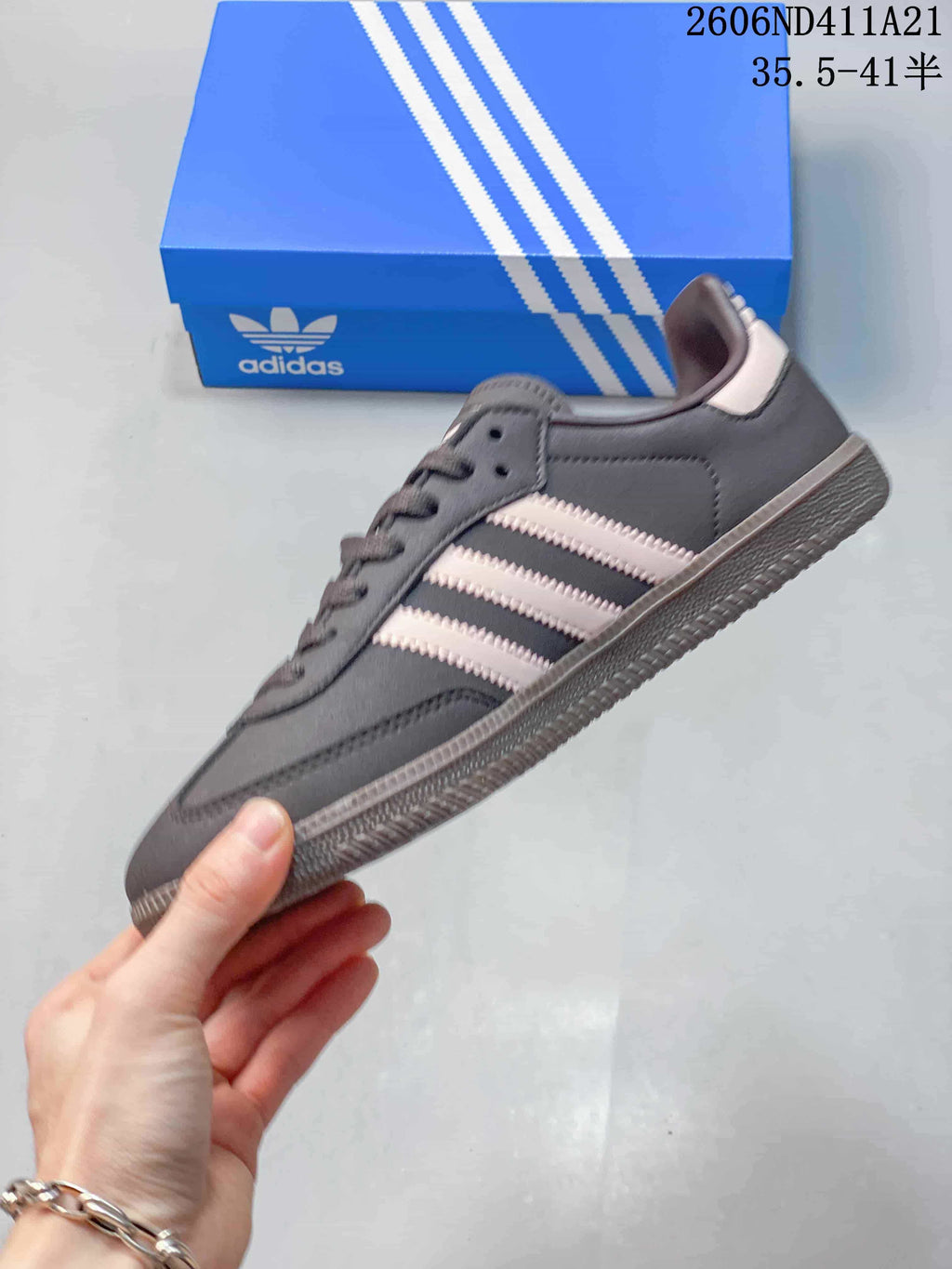Side view of the charcoal low-top sneaker with pale pink stripes and a gum-tone outsole.