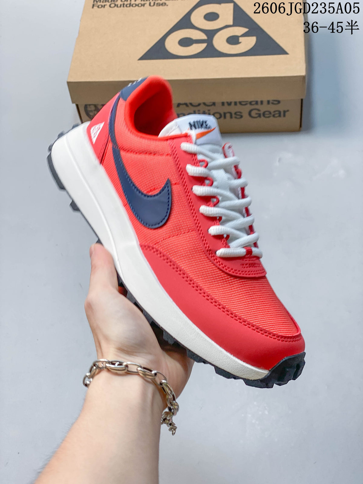 Side view of a red Nike ACG LDV shoe with a dark blue logo and lugged outsole