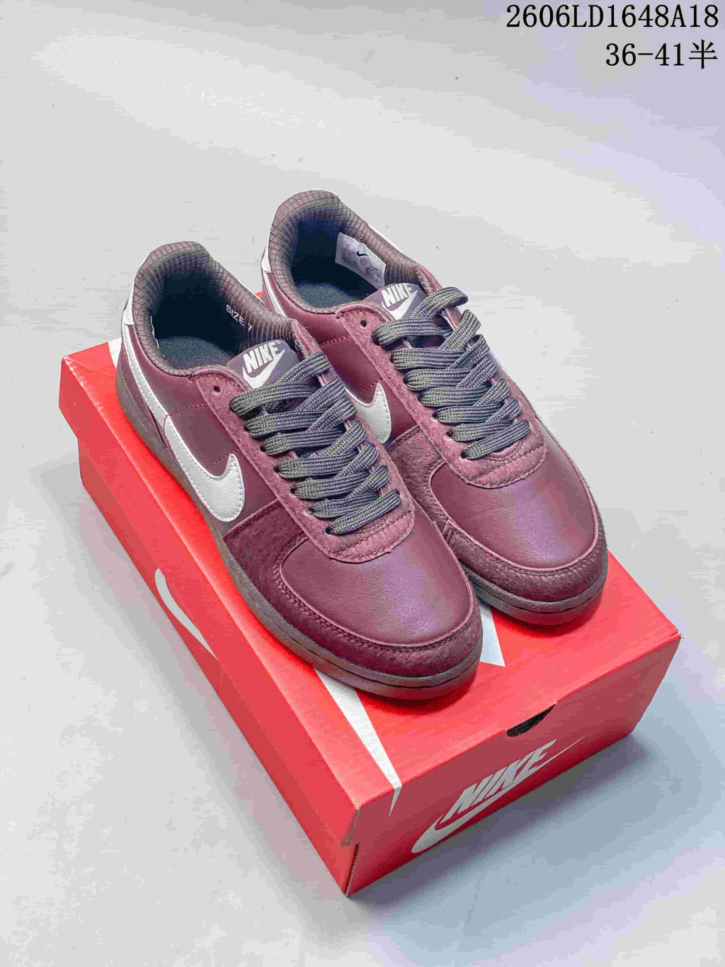 Pair of burgundy Nike Field General 82 SP low-top sneakers on a red shoe box