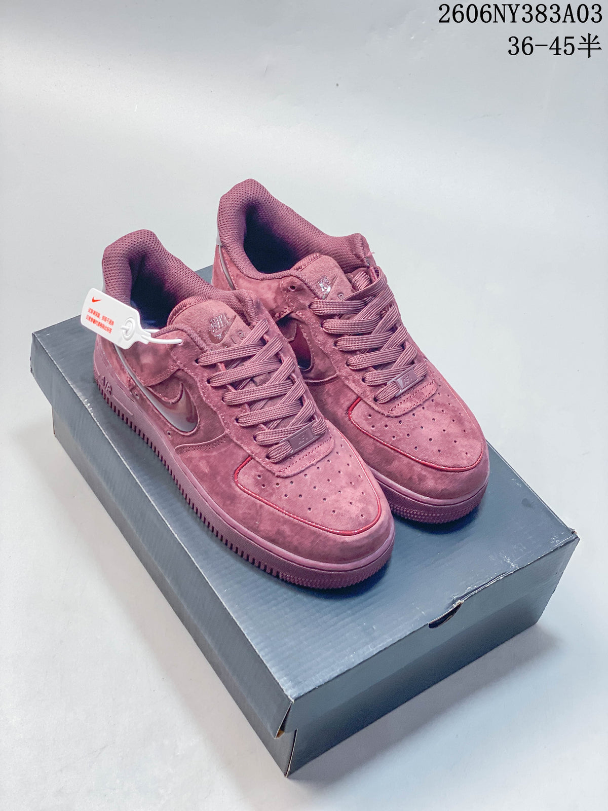 Pair of deep rose Nike Air Force 1 low-top sneakers on a shoe box