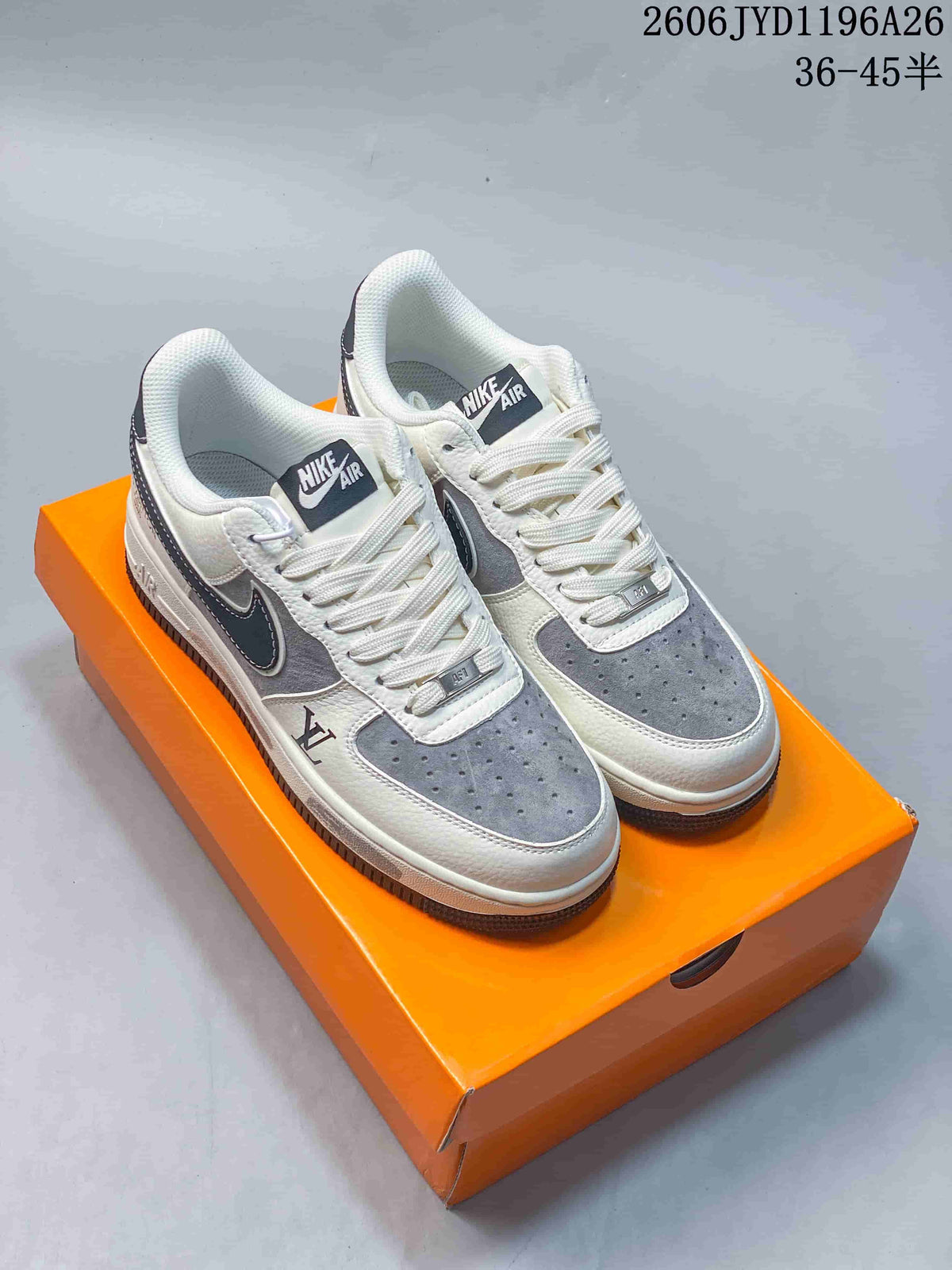 Pair of white and gray low-top sneakers with perforated toes and patterned laces on an orange box.