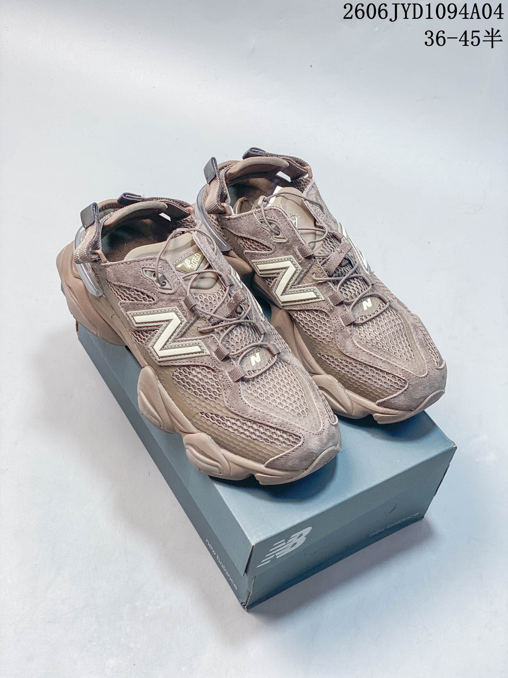 Pair of taupe-toned New Balance 204L sneakers shown from the front and side
