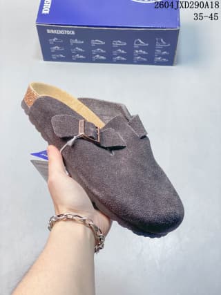 Dark brown suede closed-toe clog with a metal buckle and contrasting footbed edge.