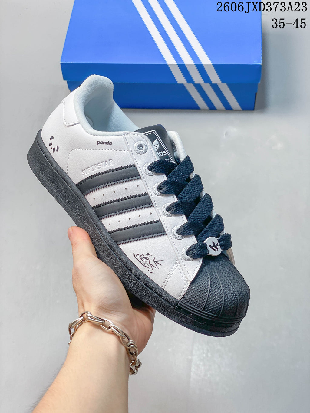 Angled side view showing the sneaker's panda graphic, dark stripes, and dark sole.