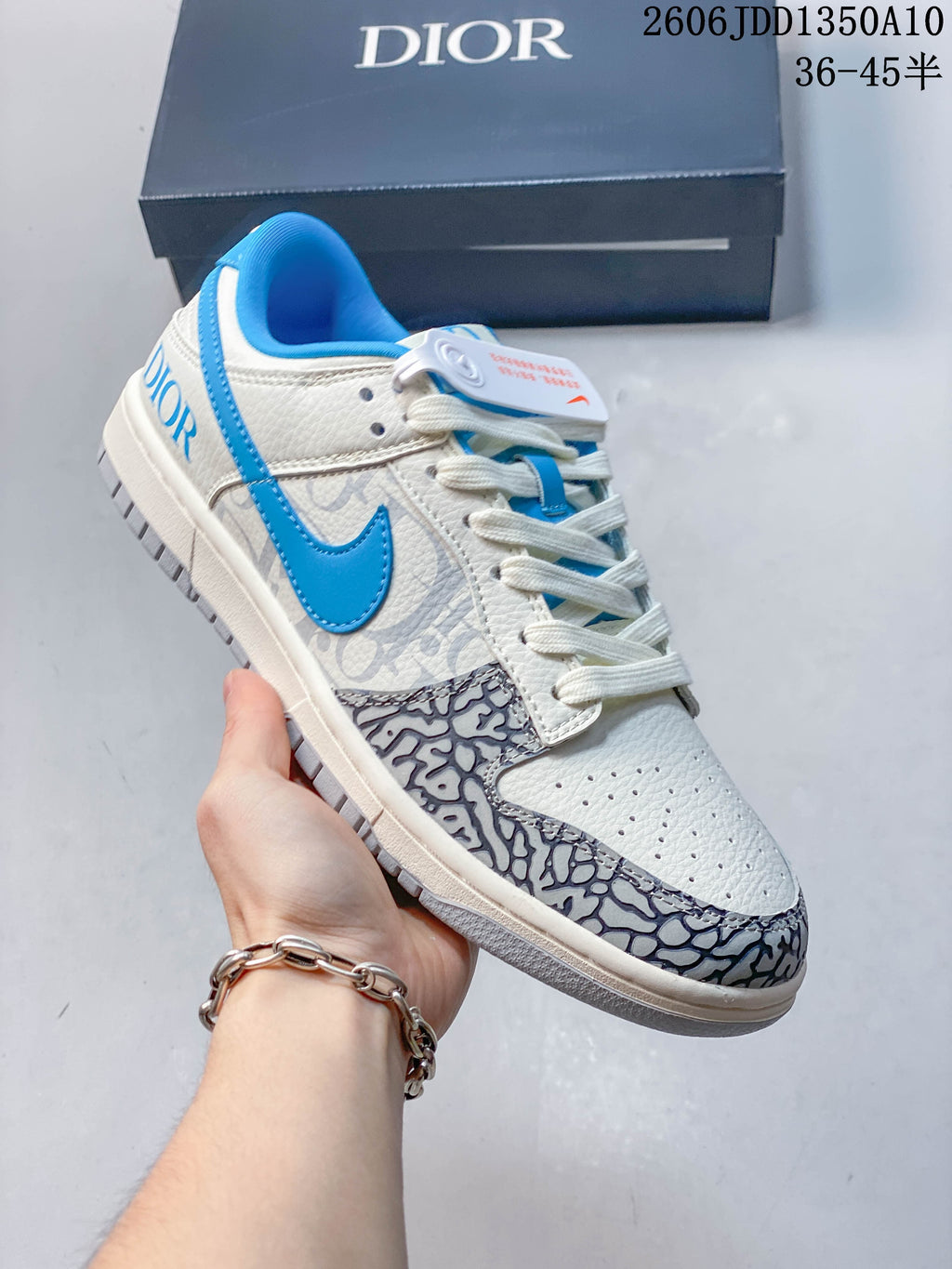 Angled side view of the sneaker with blue swoosh, white upper, and gray patterned panels.