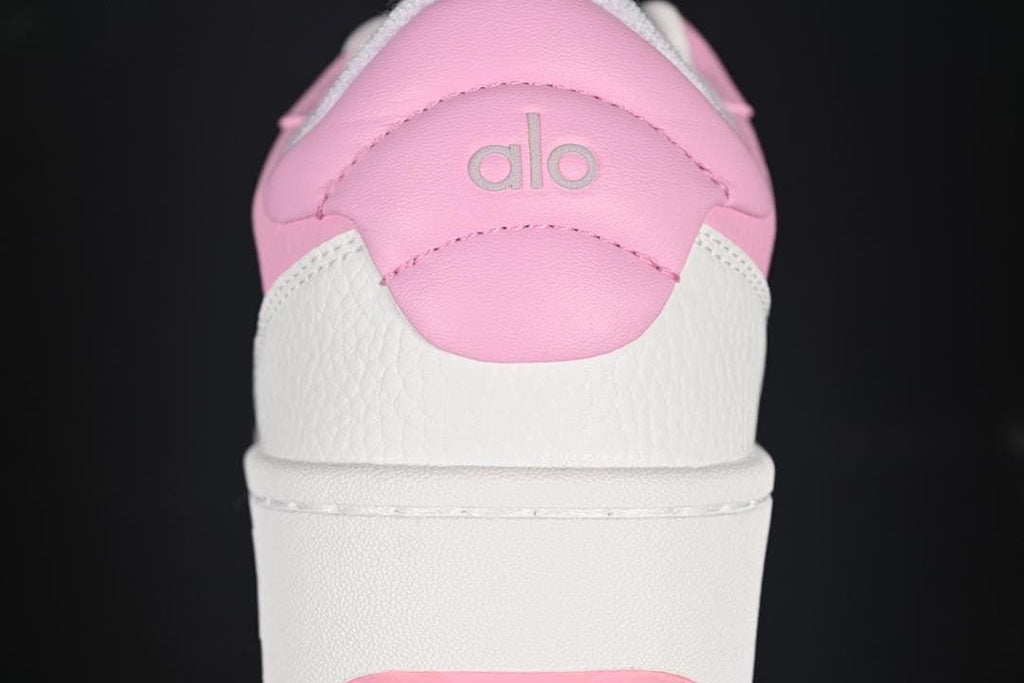 Rear view showing pink heel panels, white overlays, and Alo branding