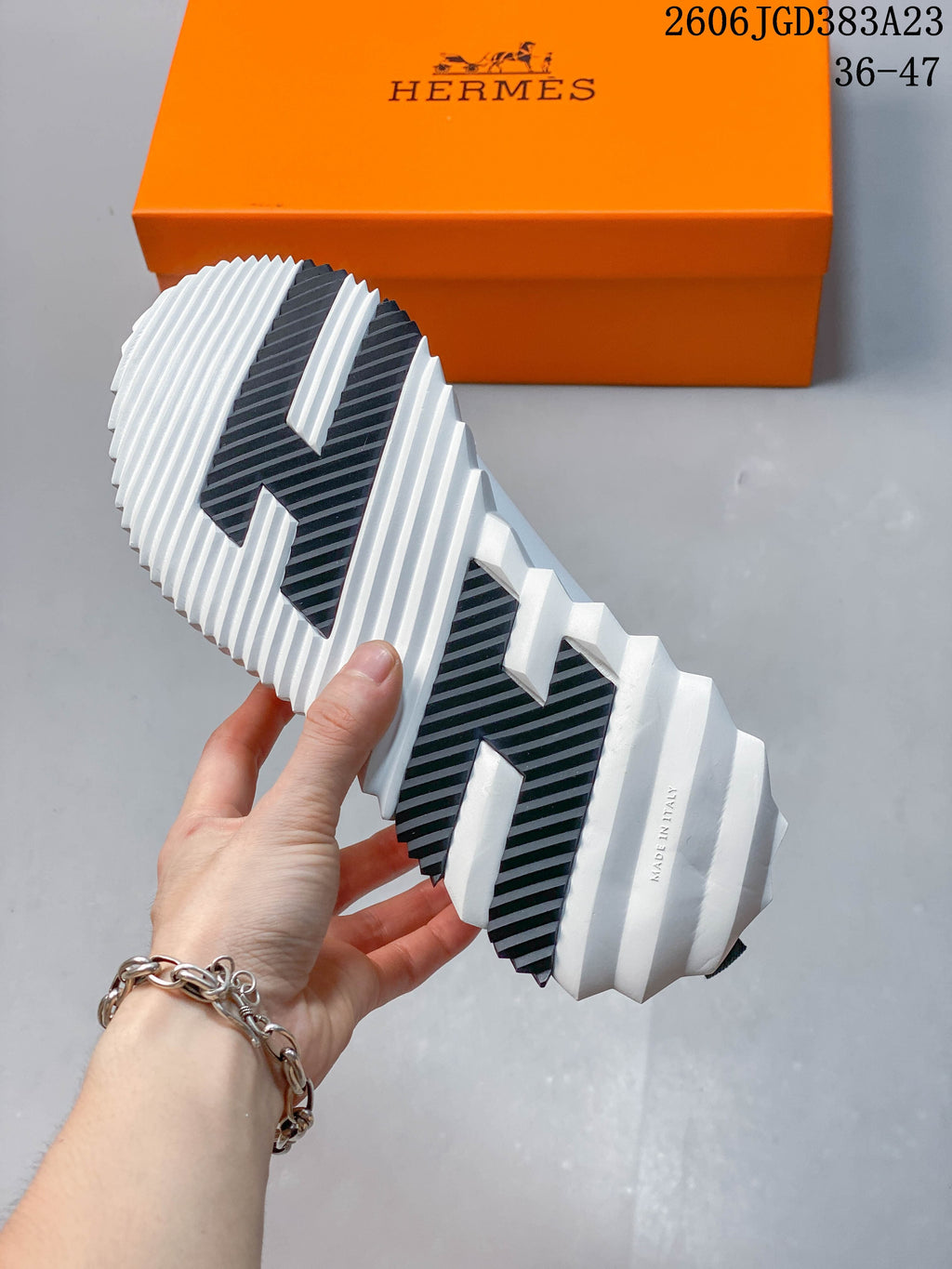 Underside of the sneaker showing a white ridged sole with dark traction panels.