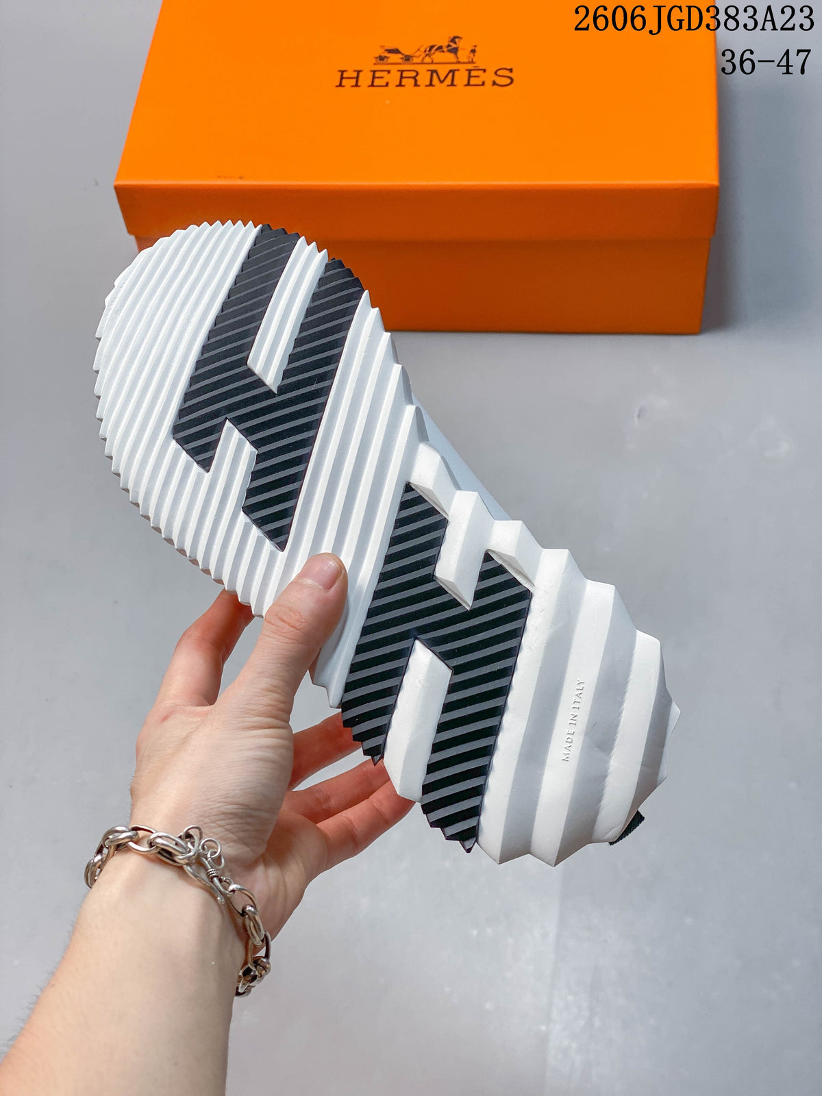 Underside of the sneaker showing a white ridged sole with dark traction panels.
