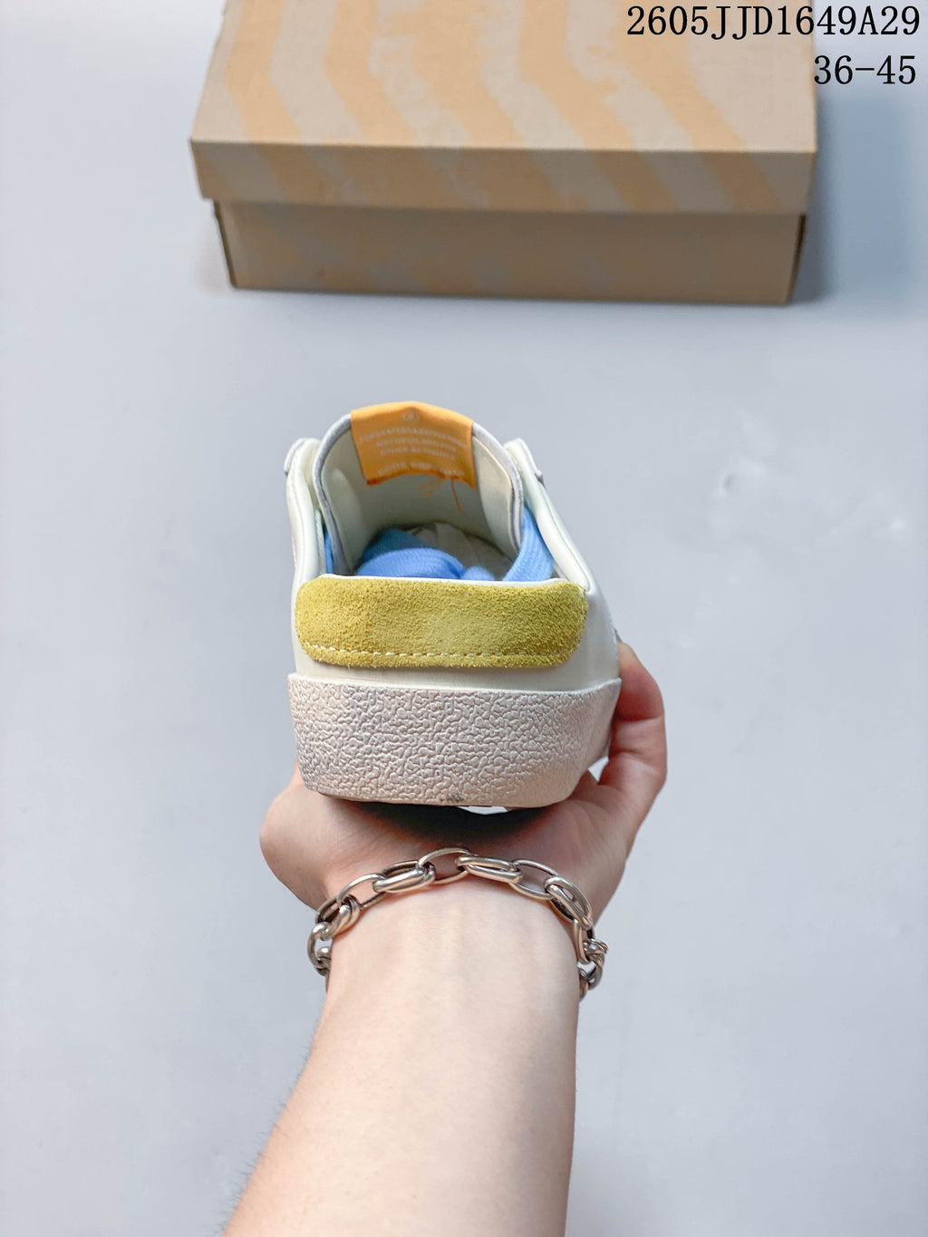 Rear view of the sneaker showing its yellow heel accent and textured sole