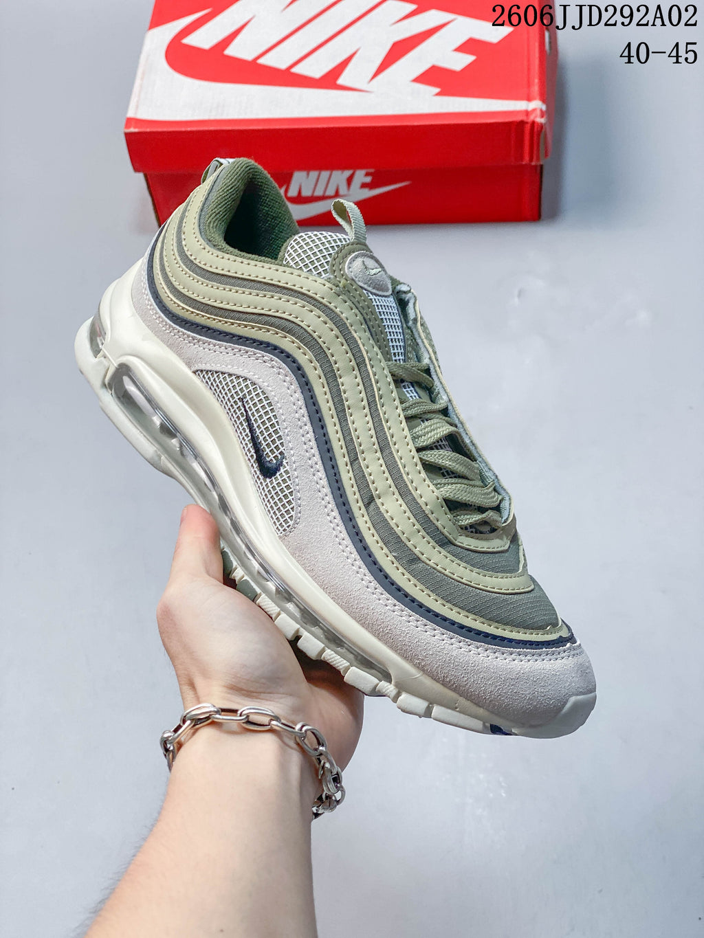 Angled side view of a Nike Air Max 97 sneaker in muted green, gray, and white