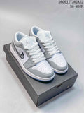 Pair of white and grey low-top Air Jordan 1 sneakers with patterned Swooshes, shown on a box