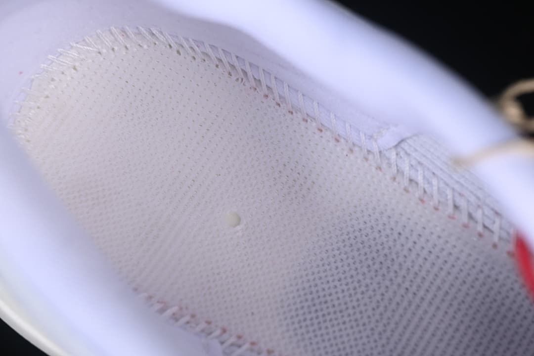 Close-up of the shoe's perforated white upper and stitching