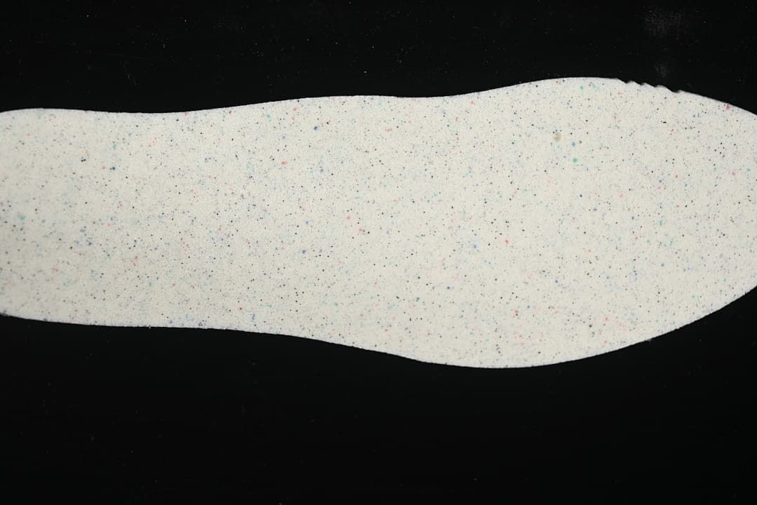 Light-colored shoe insole with multicolor speckles
