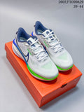Pair of white and light gray Nike Air Zoom Vomero 17 shoes with navy and bright green accents, displayed on an orange shoe box.