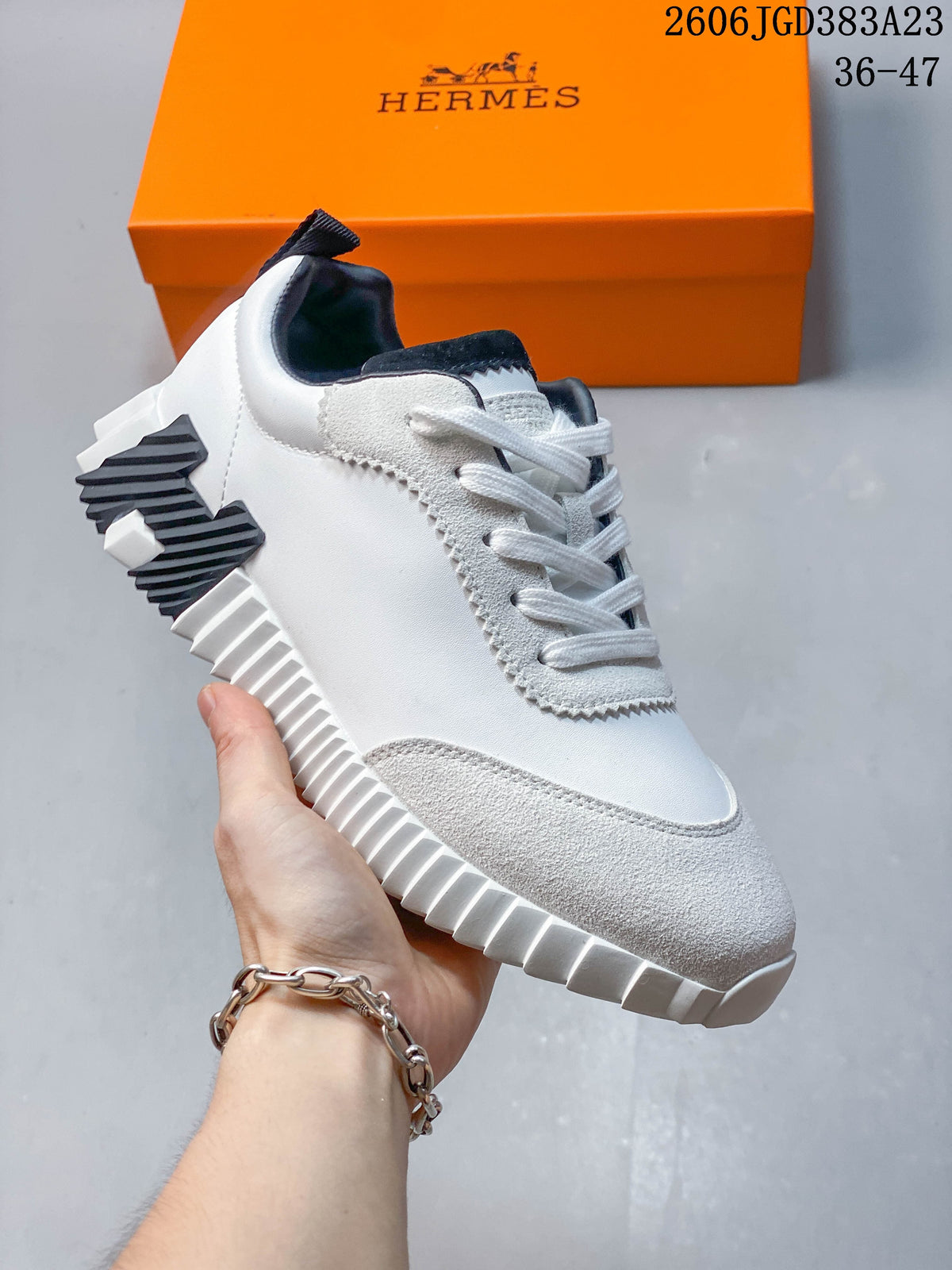 Close side view of a white low-top sneaker with a ribbed sole and dark heel accent.