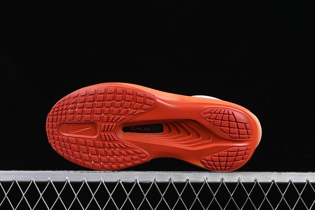 Bottom view showing the orange outsole tread and central plate area