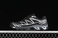 Side view of black and silver Salomon XT-6 GTX sneakers against a dark background.