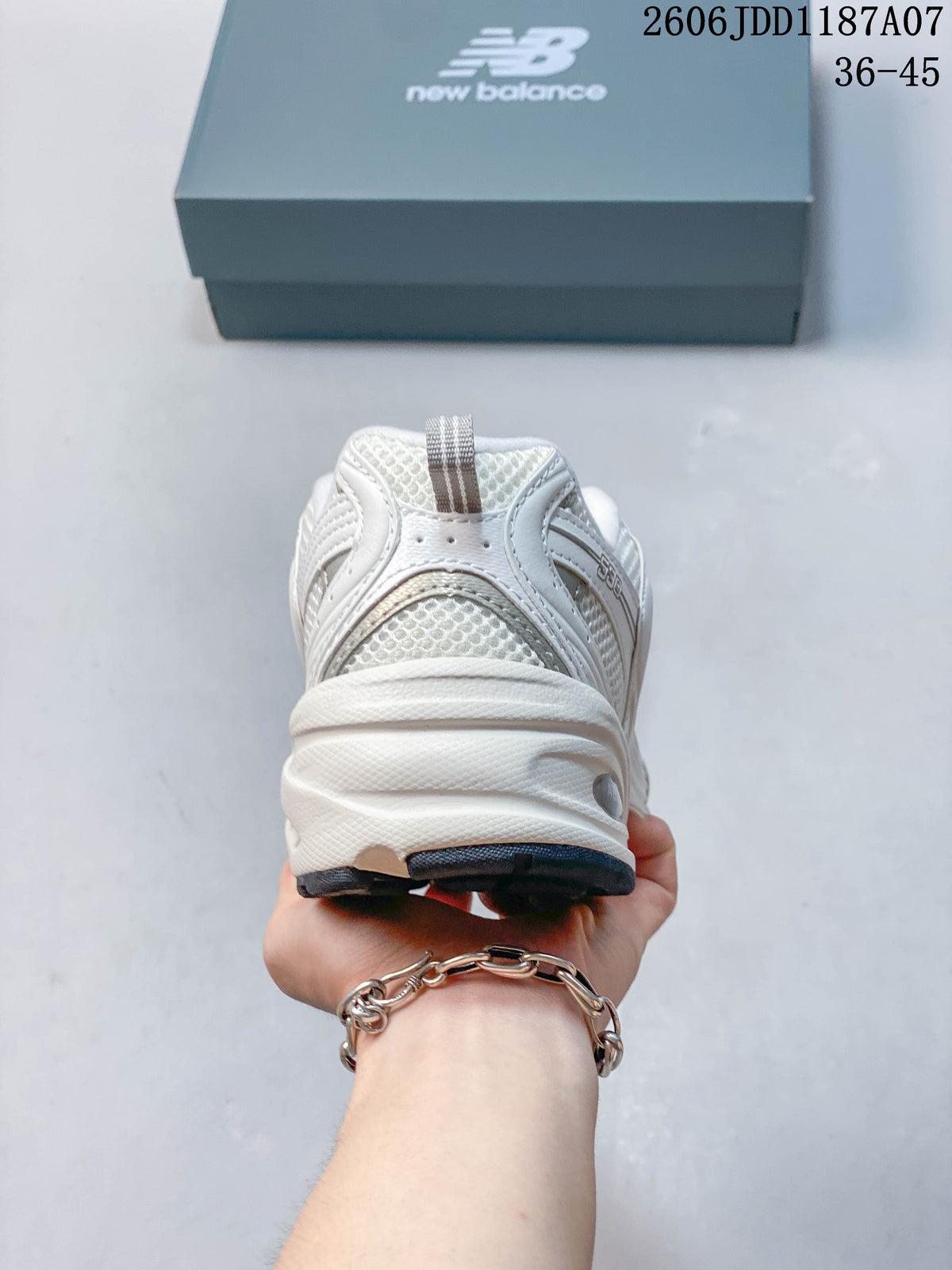 Rear view of a white New Balance 530 sneaker with mesh panels and a layered heel.