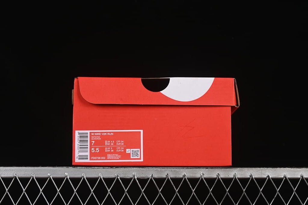 Red shoebox with a visible label identifying Nike V2K Run and style code FD0736-002
