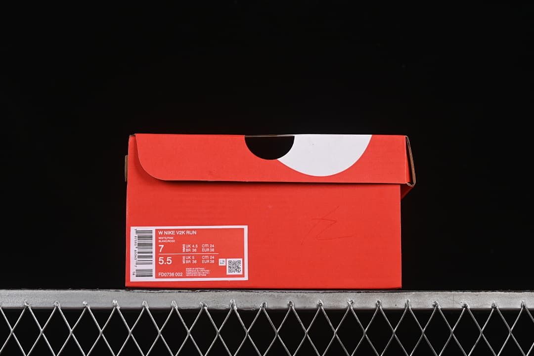 Red shoebox with a visible label identifying Nike V2K Run and style code FD0736-002