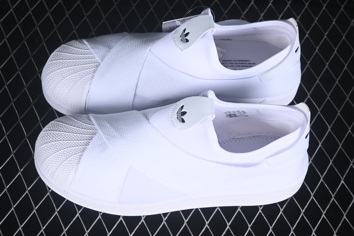 Pair of white adidas slip-on sneakers shown from an angled side view.