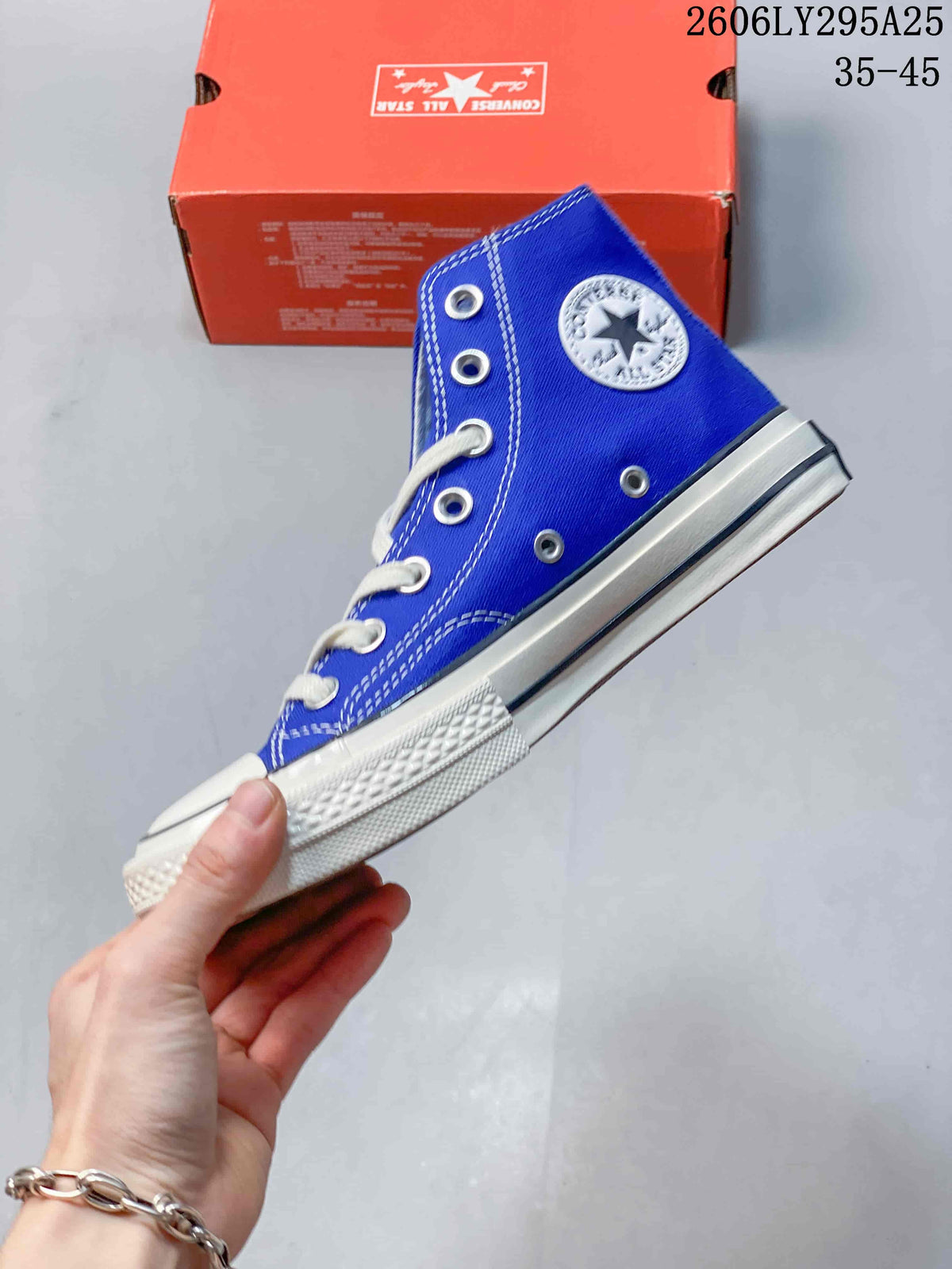 Side view of a blue high-top sneaker with a circular ankle patch