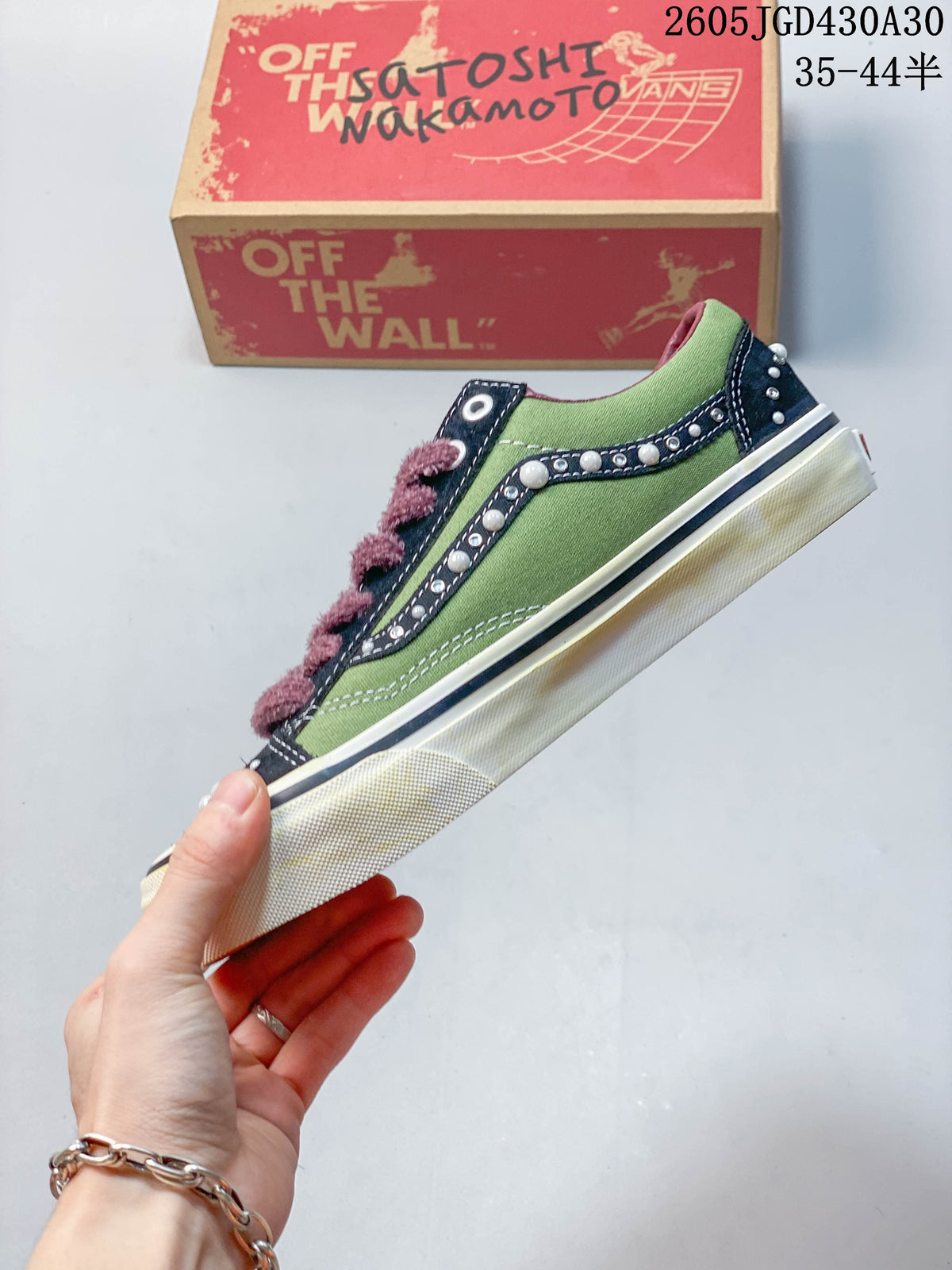 Side view of a green and navy Vans LX Old Skool sneaker with pearl-like accents and plush mauve laces.