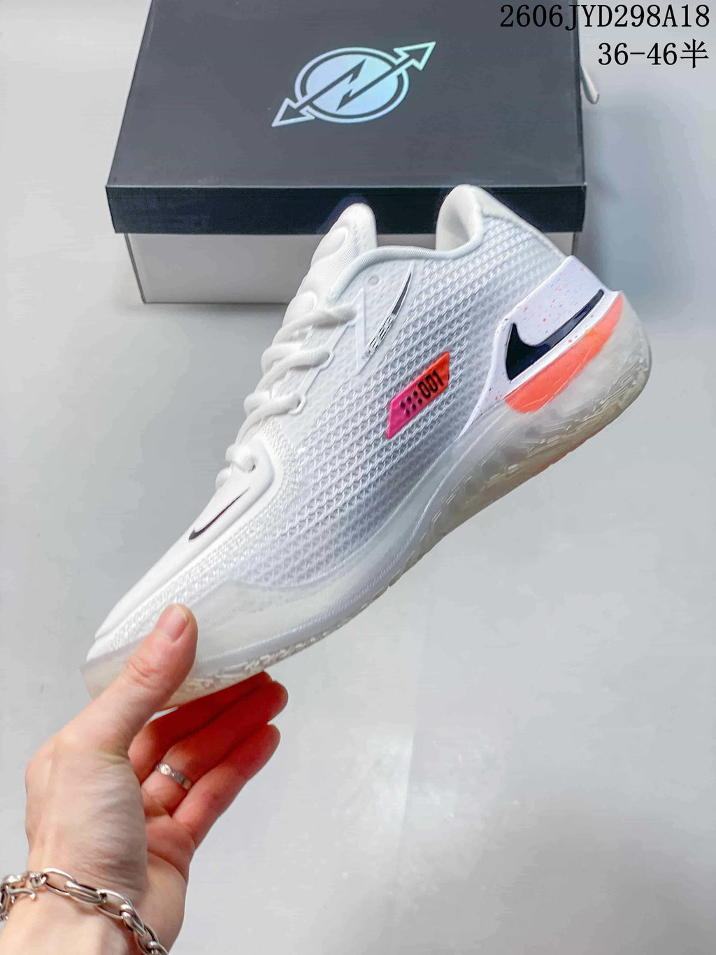 Side view of a white Nike Air Zoom GT Cut shoe with black Swoosh and coral accents