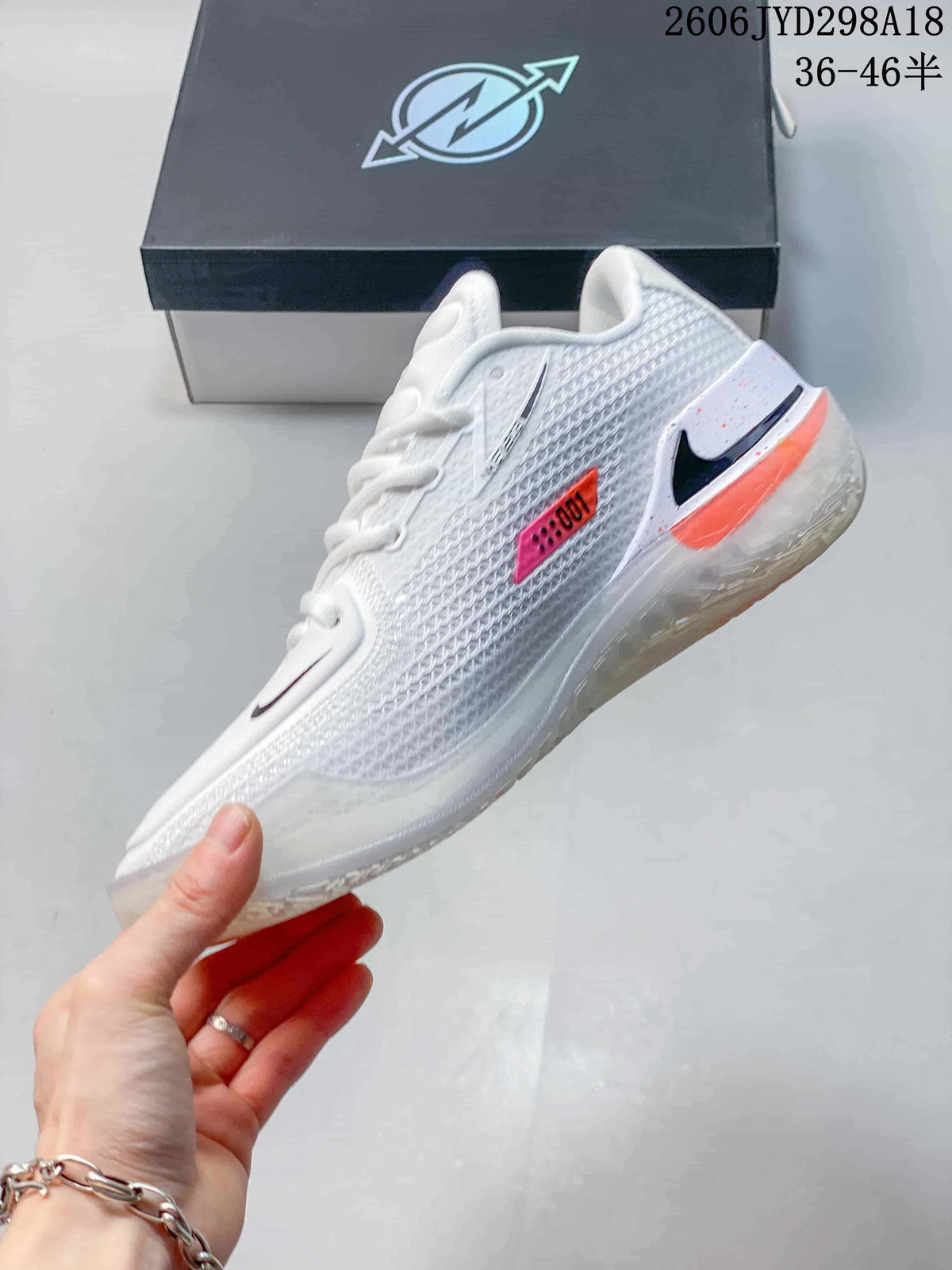 Side view of a white Nike Air Zoom GT Cut shoe with black Swoosh and coral accents