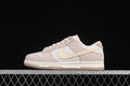 Side view of pink, white, and pale yellow Nike SB Dunk Low sneakers